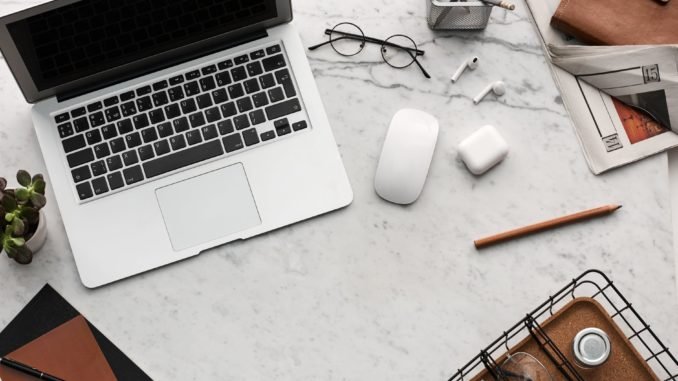 flatlay display of electronics next to eyeglases